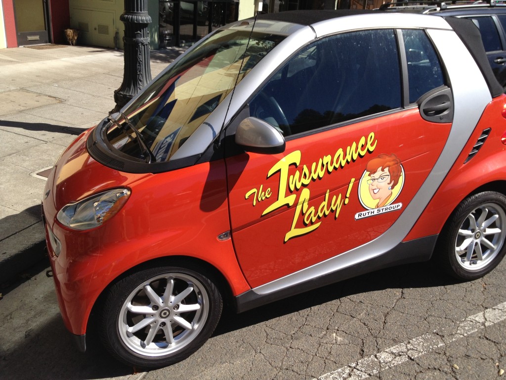 To the Ruthmobile! Ruth's little red Smart car was already a neighborhood institution. Insurance Lady graphics made it even more fun and eye-catching. Everyone needs their Own-Mobile.
